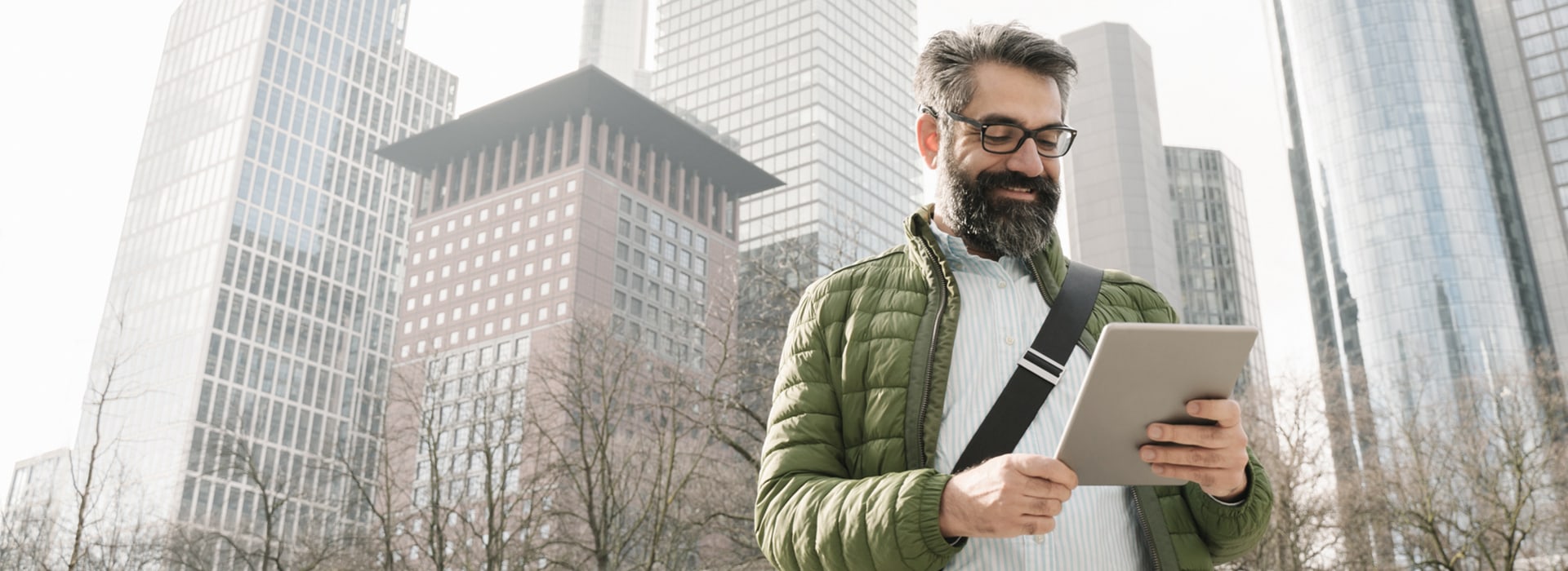 Man with tablet in front of a skyline