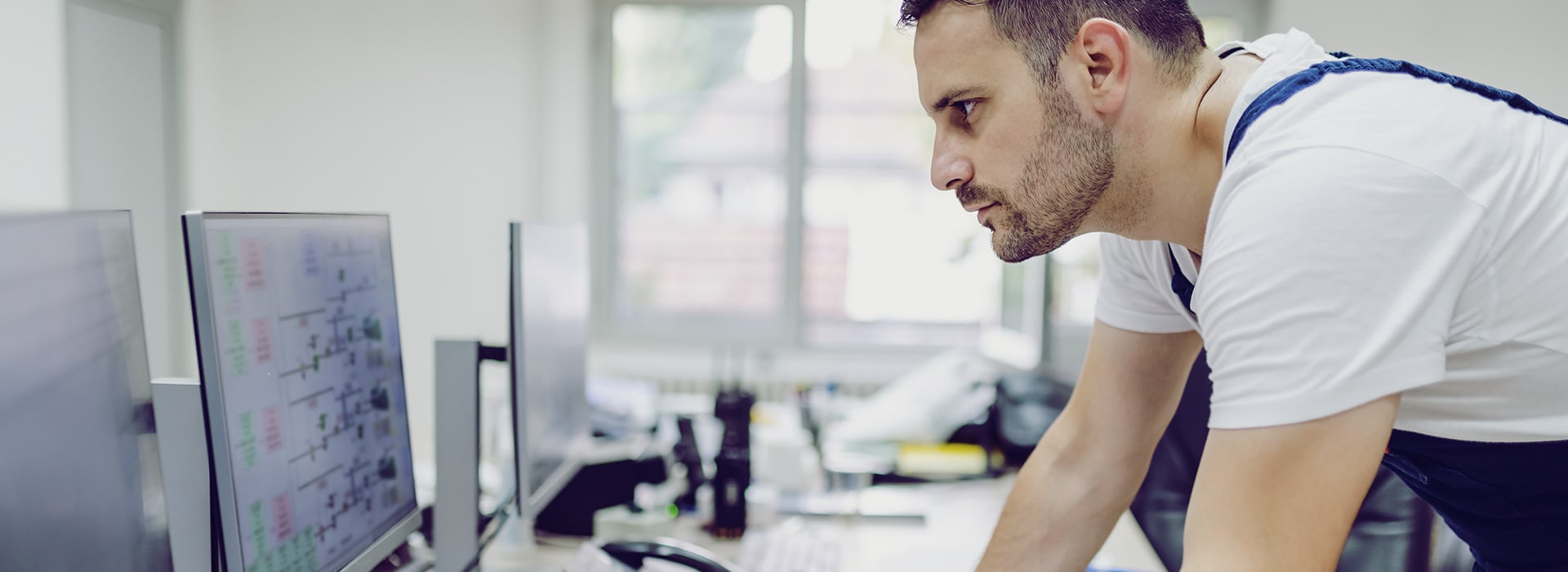 Man standing at a desk and looking at something on a screen