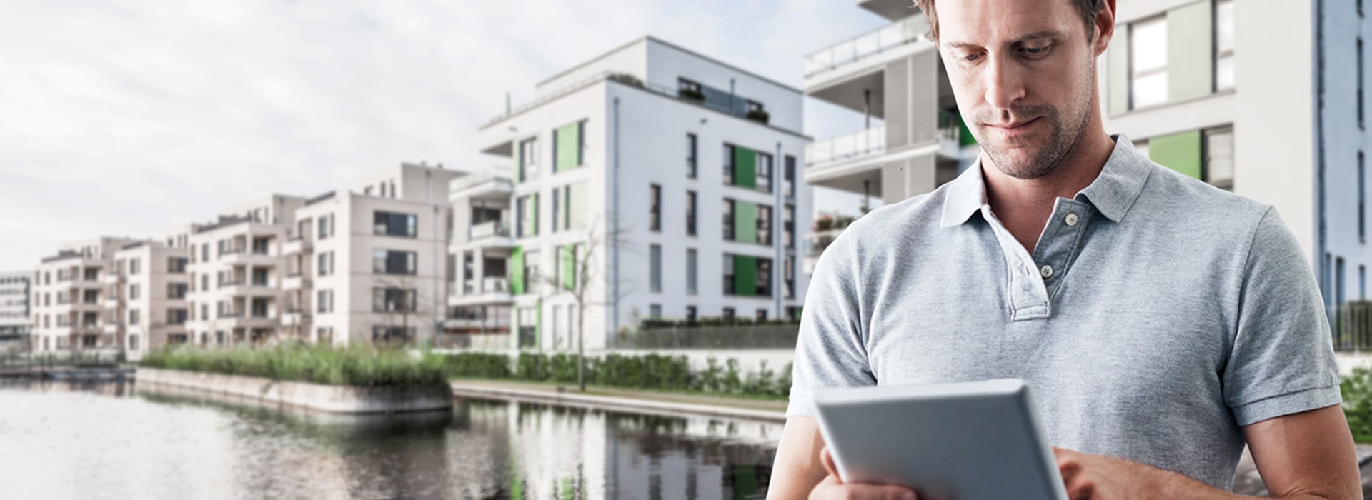 A man with a tablet in front of buildings